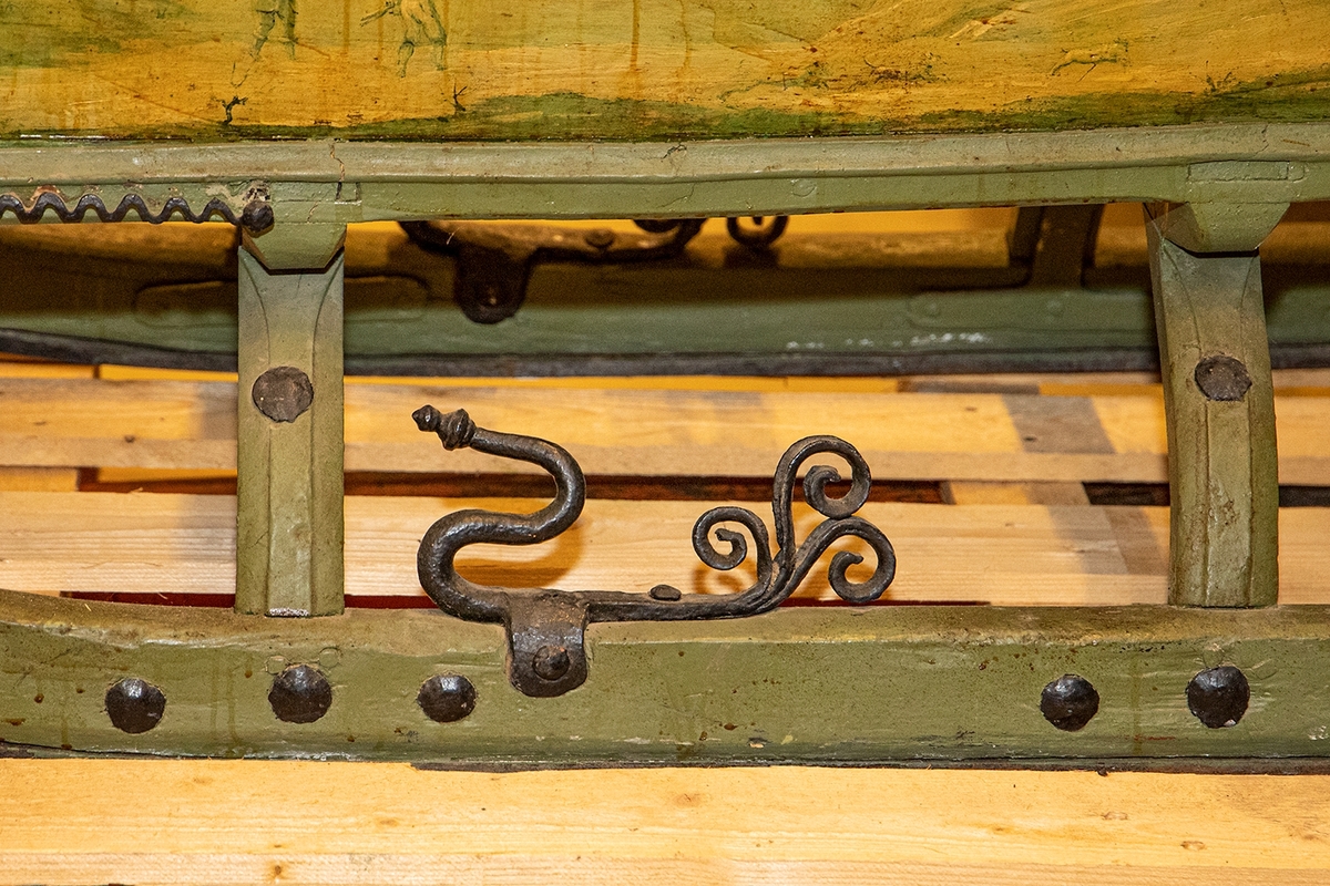 Släde, enspännare av furuträ. Grönmålad. Med järnbeslag. Kuskbockssadel ("hundsfott") samt plats för en passagerare. I sätet en infälld lucka, förvaringsutrymme. Kuskbocksbrädan samt sätets sid- och ryggstycken stoppade med hö, foder juteväv, klädda med grävlingskinn. Framtill stänkskydd för passageraren av svart impregnerad duk

Rikt dekorerad med målningar i Rokokostil.