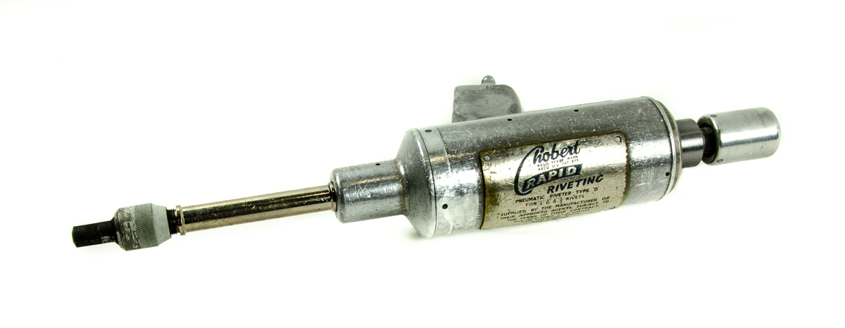 Luft "Chobert" för nitning
Nitmaskin av metall från Aviation Development Ltd., "Chobert" rapid riveting typ 'D' i specialtillverkad trälåda. Verktyget är utformat som en silverpistol med avtryckare för att starta maskinen. Ett tryckluftsintag är placerat under handtaget. Lådan är försedd med grön stopning på insidan och det ingår nitsitft.