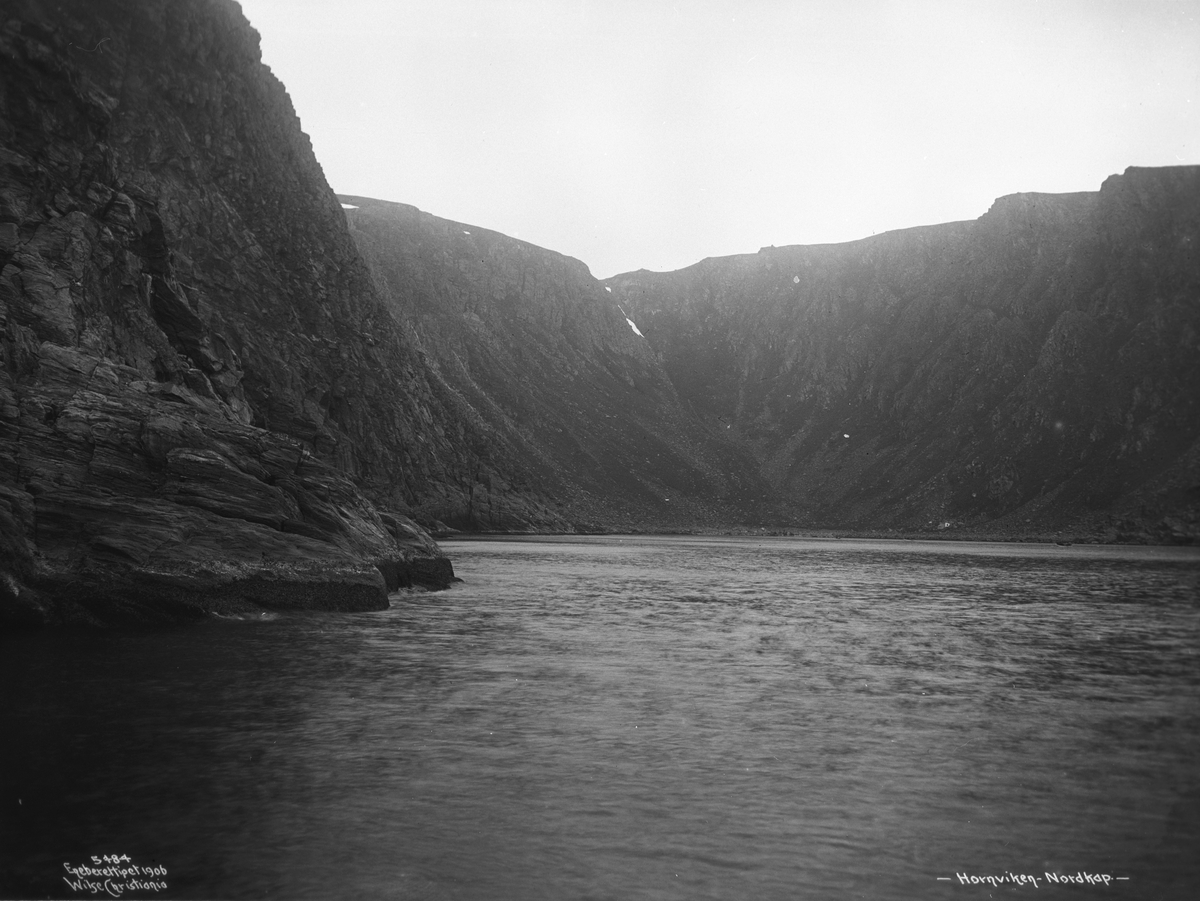 Hornvika sett fra sjøen. Før veien til Nordkapp stod ferdig i 1956 måtte alle besøkende skipes i land i Hornviken og derifra ta seg opp en bratt stigning til selve Nordkapplatået. Fotografert i juli 1906.