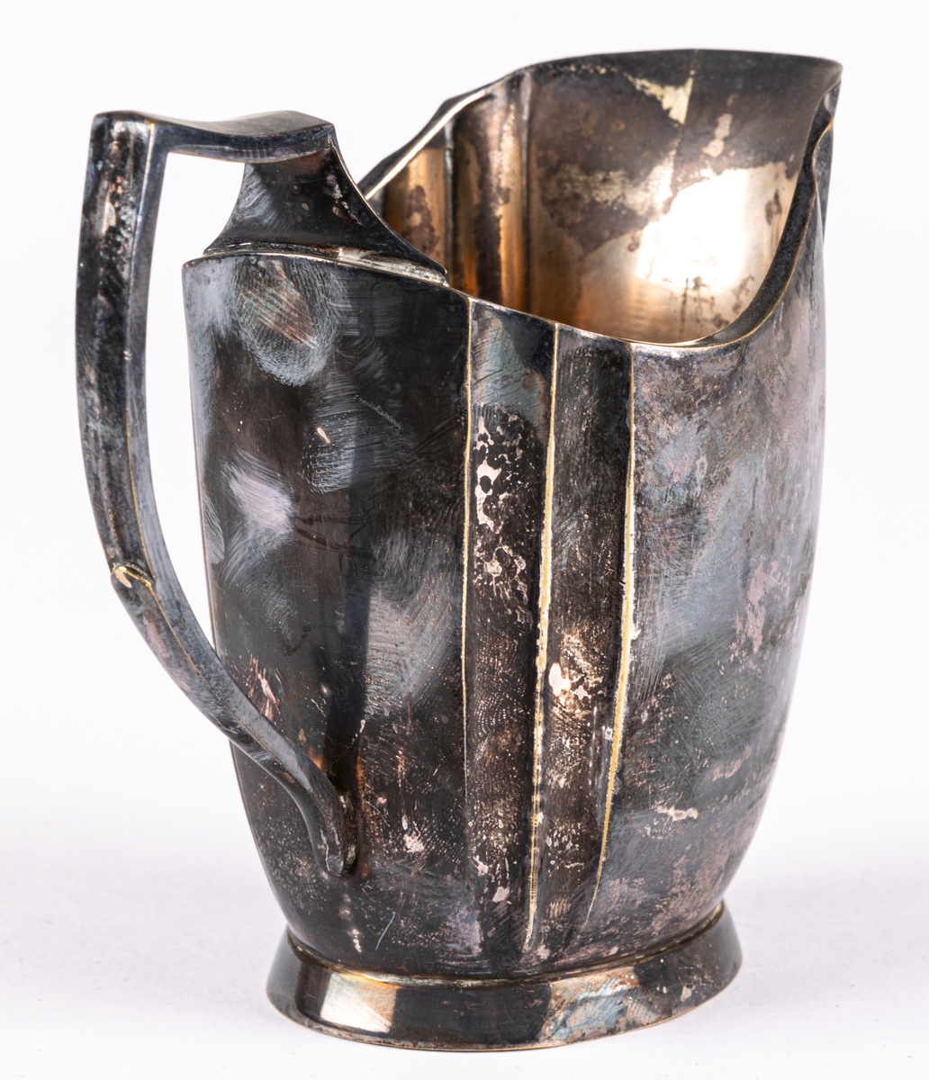 Gräddkanna. Nysilver med snip och lodgrepe. På undersidan stämplar.