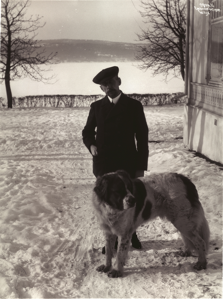 Roald Amundsen og hunden utenfor villaen Uanienborg. Fotografert 7. mars 1909.