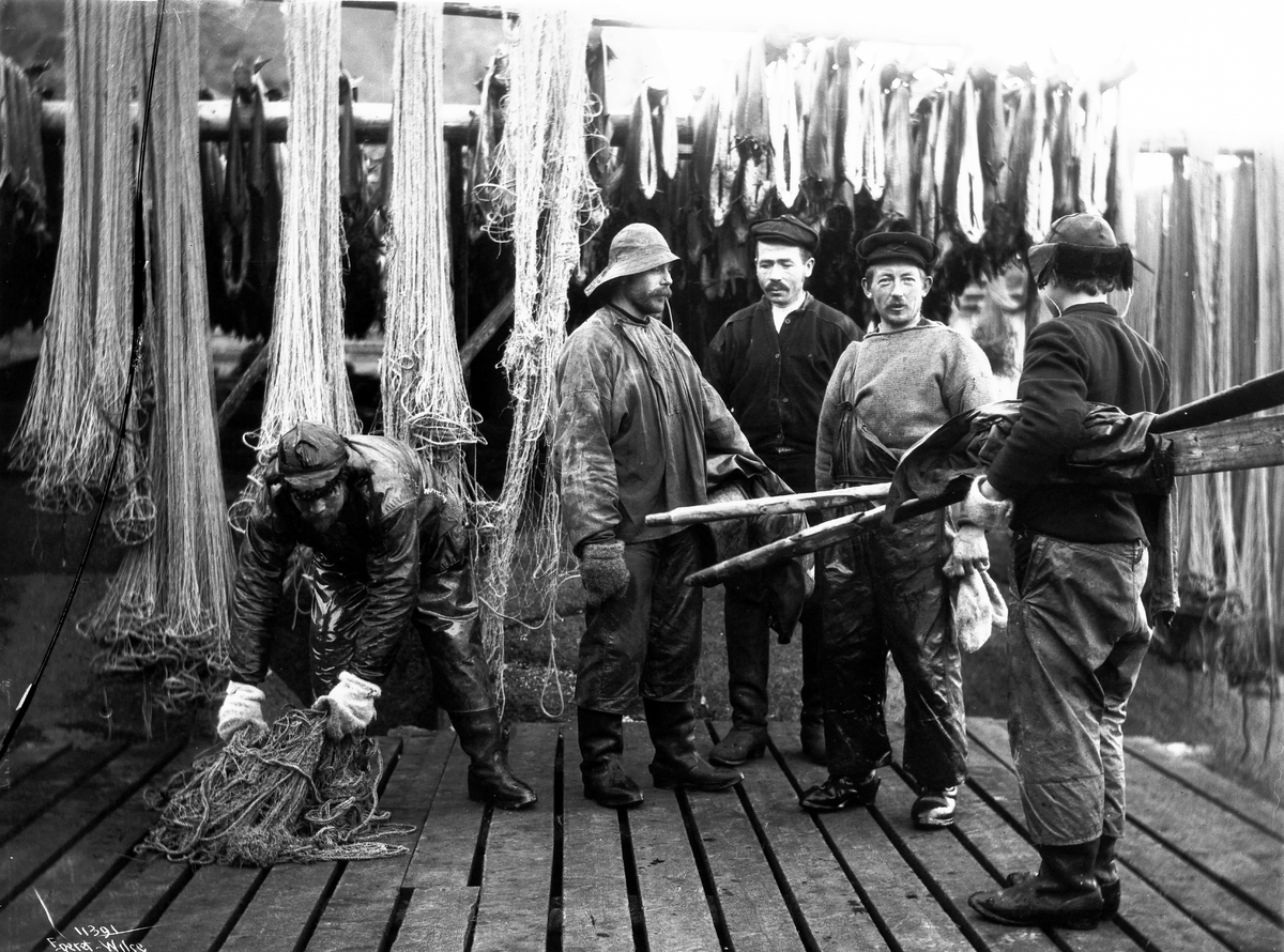 En gruppe fiskere og fiskegarn, antatt fra Svolvær, Vågan, Lofoten, Nordland 10.03.1910.