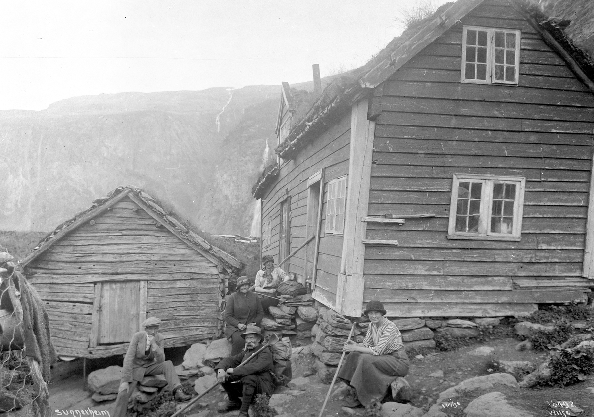 Fjellvandrere sitter på tunet ved fjellgården Sinjarheim (cirka 600 moh), Aurland, Sogn og Fjordane, 1914.