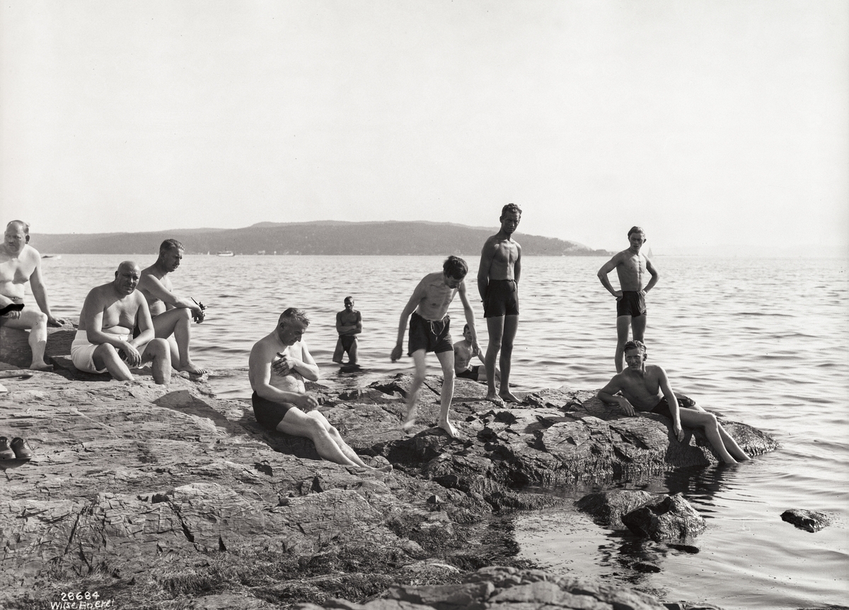 Badeliv, svaberg i strandkanten, menn i alle aldre.