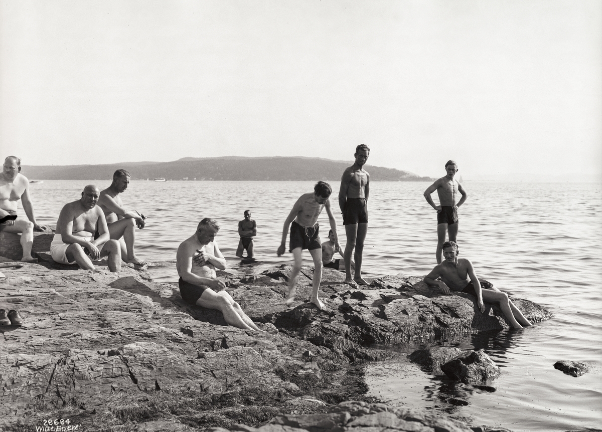 Badeliv, svaberg i strandkanten, menn i alle aldre.