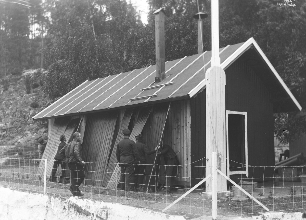 Mannskap reparerer uthuset hvor de overvintret ved villaen til Roald Amundsen. Fotografert 03.06.1910.