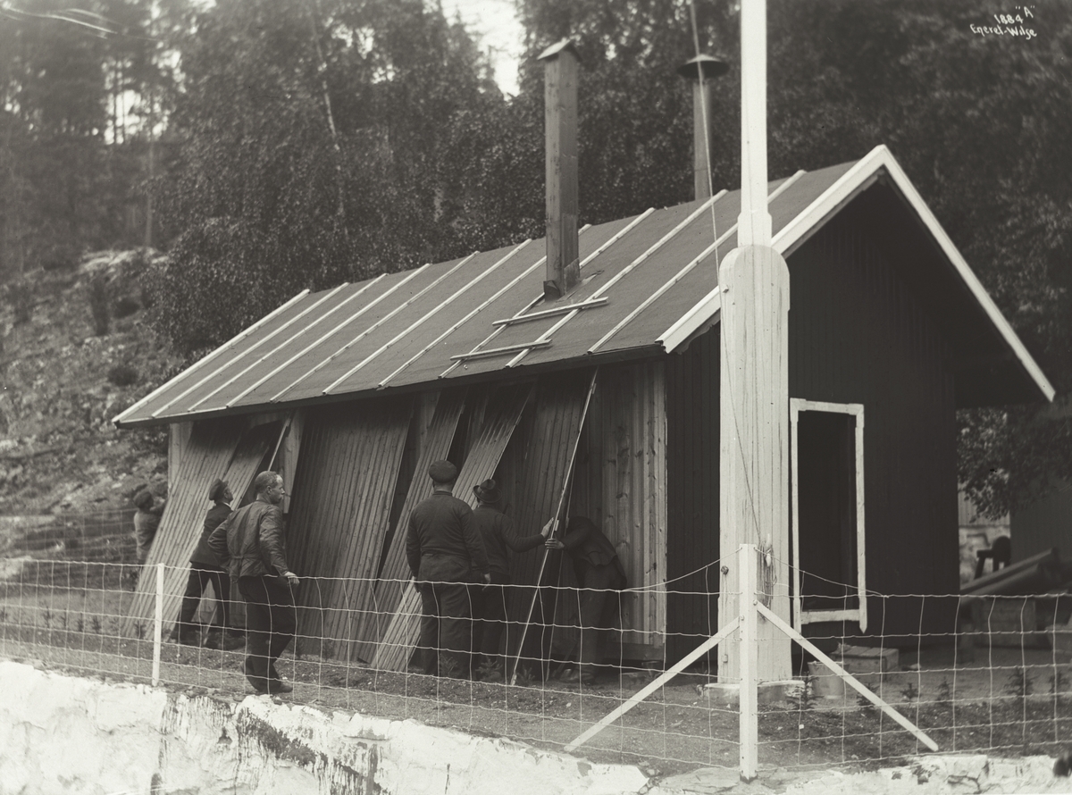 Mannskap reparerer uthuset hvor de overvintret ved villaen til Roald Amundsen. Fotografert 03.06.1910.