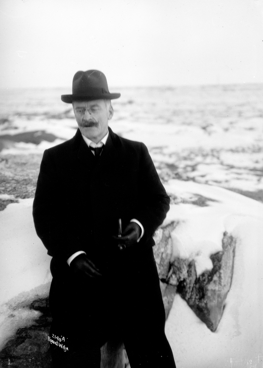 Portrett av Knut Hamsun ved en båt. Fotografert 1913.