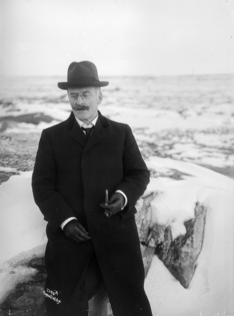 Portrett av Knut Hamsun ved en båt. Fotografert 1913.