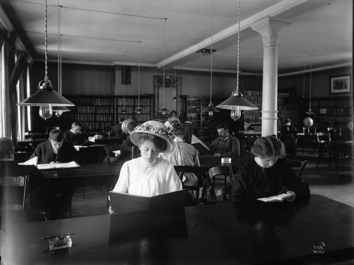 Bibliotekets lesesal, yngre kvinner og menn, antatt studenter, i dyp konsaentrasjon.