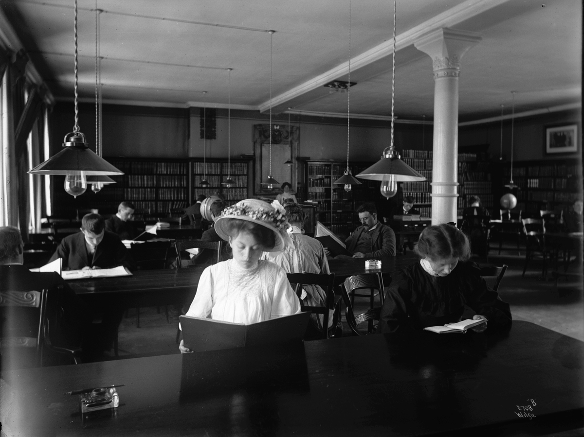 Bibliotekets lesesal, yngre kvinner og menn, antatt studenter, i dyp konsaentrasjon.