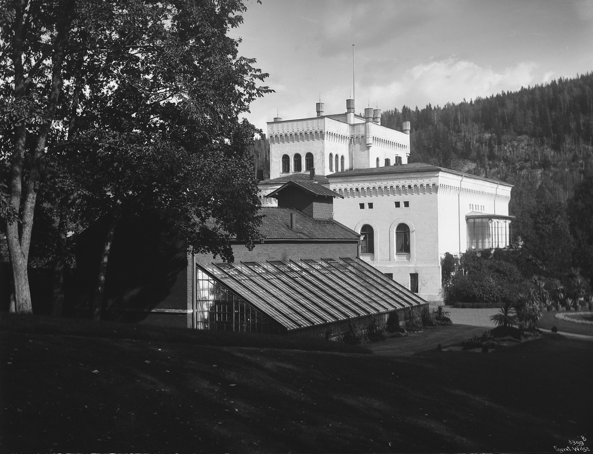 Vestfasaden på hovedbygningen til Bærums Verk, med drivhus i forgrunnen. Fotografert 1911.