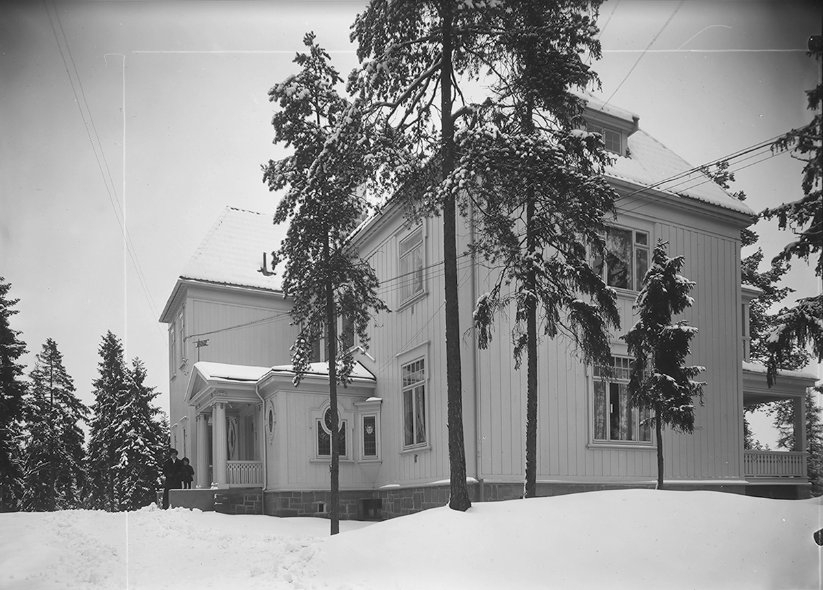 Jul Thomassens hus på Slemdal i Oslo. En kvinne og et barn skimtes foran inngangen. Fotografert 1912.