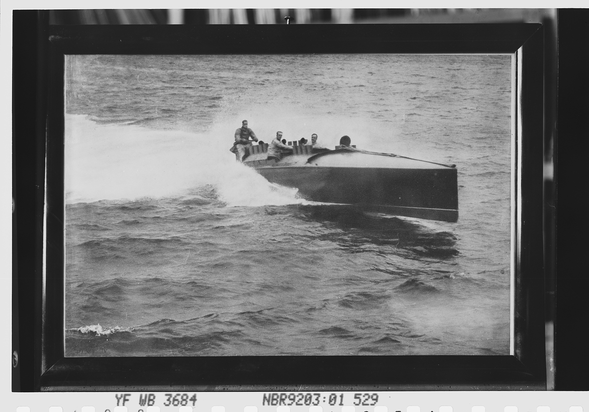 Motorbåt med tre menn ombord. Avfotografert 1912.