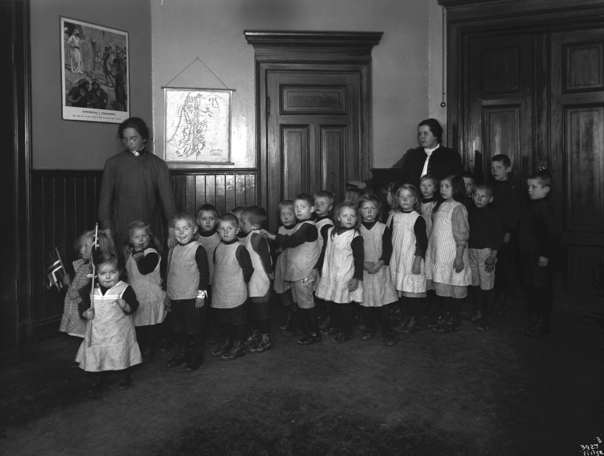 En gruppe små barn med pleiere, berboere på Barnehjemmet Tryg Gruppe.