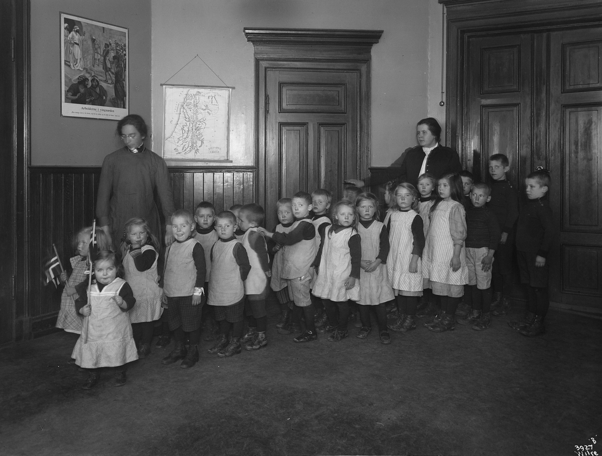 En gruppe små barn med pleiere, berboere på Barnehjemmet Tryg Gruppe.