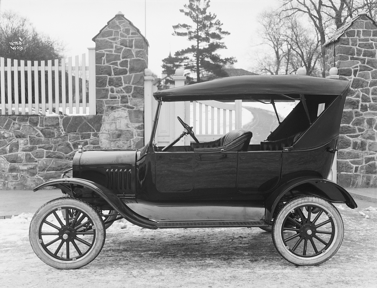 En bil fra Gjestvang automobilforretning A/S står foran porten til Bymuseet.