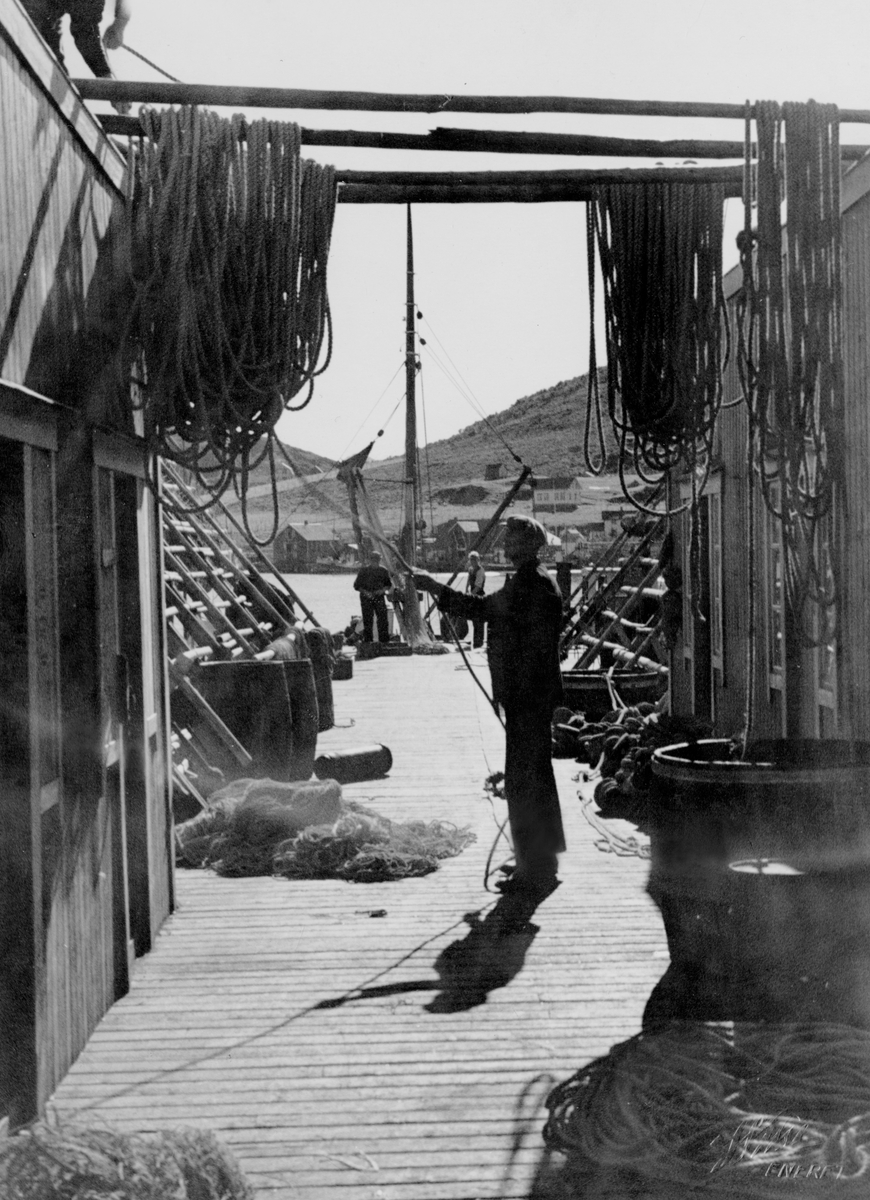 Brygge, delvis overbygget.  Her henger garn til tørk og fiskehjell klar til tørking av fangsten.