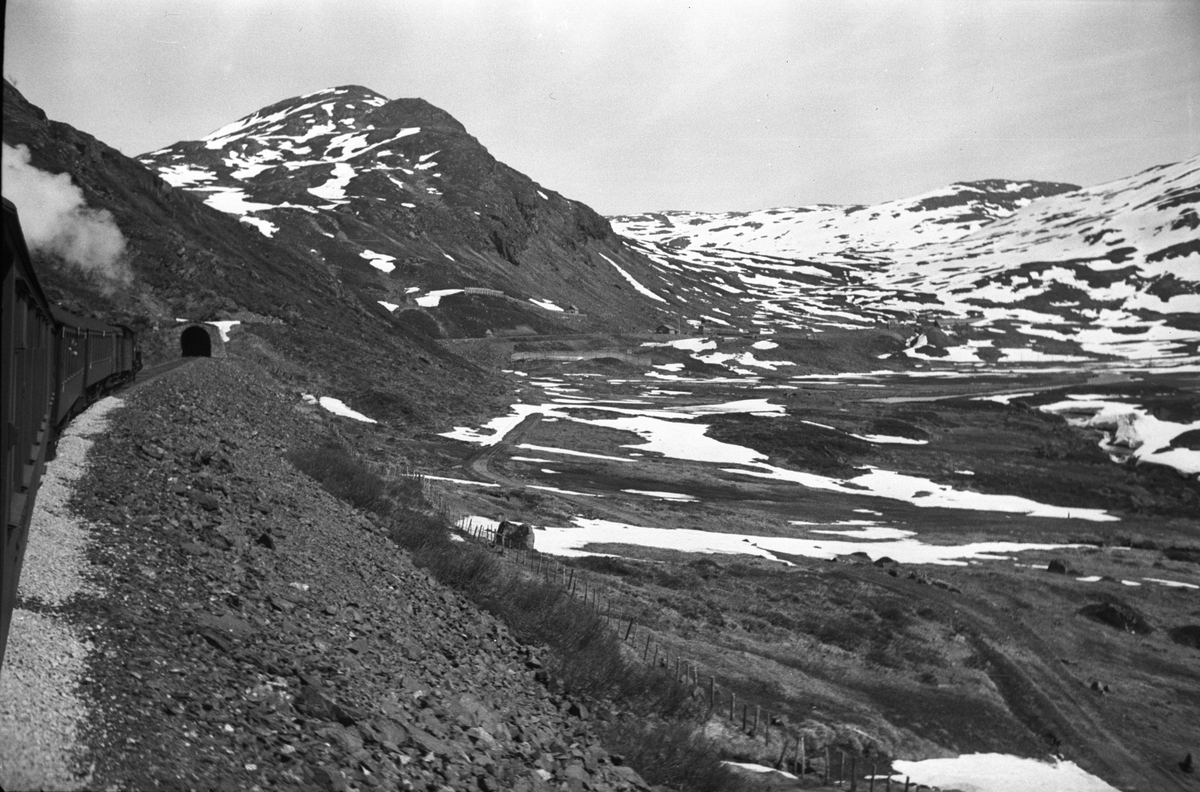 Hardangervidda, her jernbanespor og togtrafikk mellom Mjølfjell og Opset, tunnellen skimtes i bakgrunnen.