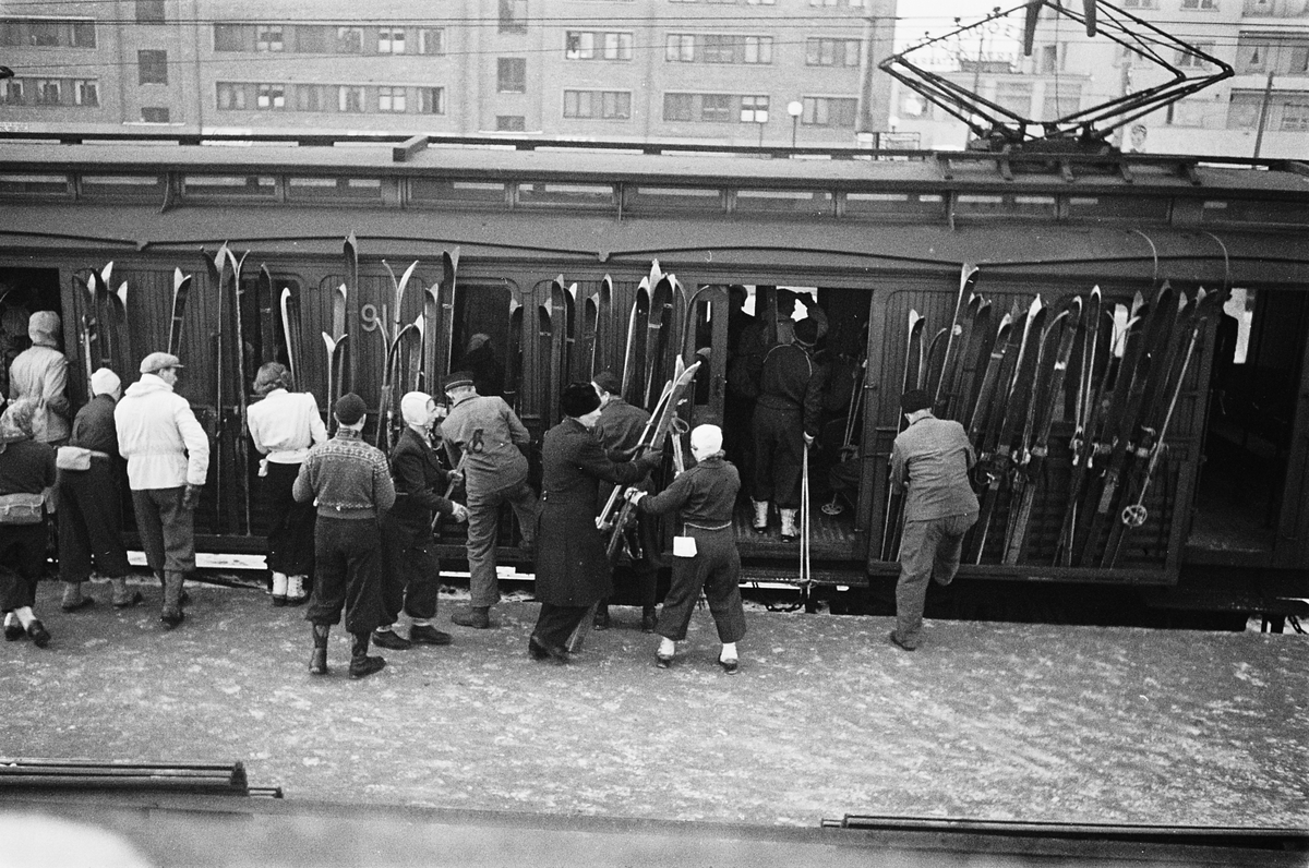 Påstigning med skikledde mennersker på Holmenkollbanen ved Majorstuen Stasjon. Fotografert 1940.