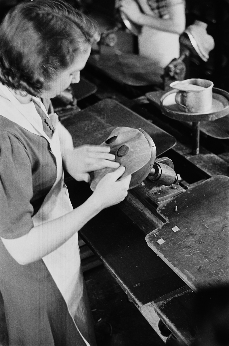 Kvinnelig arbeider ved gassmaskeproduksjonen ved Askim Gummivarefabrikk. Fotografert 1940.