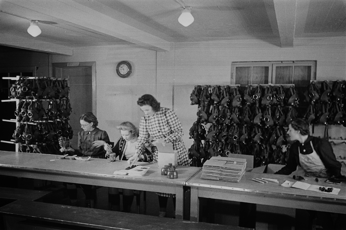 Kvinnelige arbeidere ved gassmaskeproduksjonen ved Askim Gummivarefabrikk. Fotografert 1940.