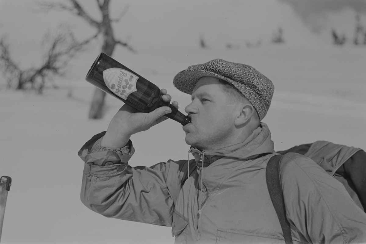 Påsketurist på ski tar seg en Pilsner-Øl. Fotografert 1940.