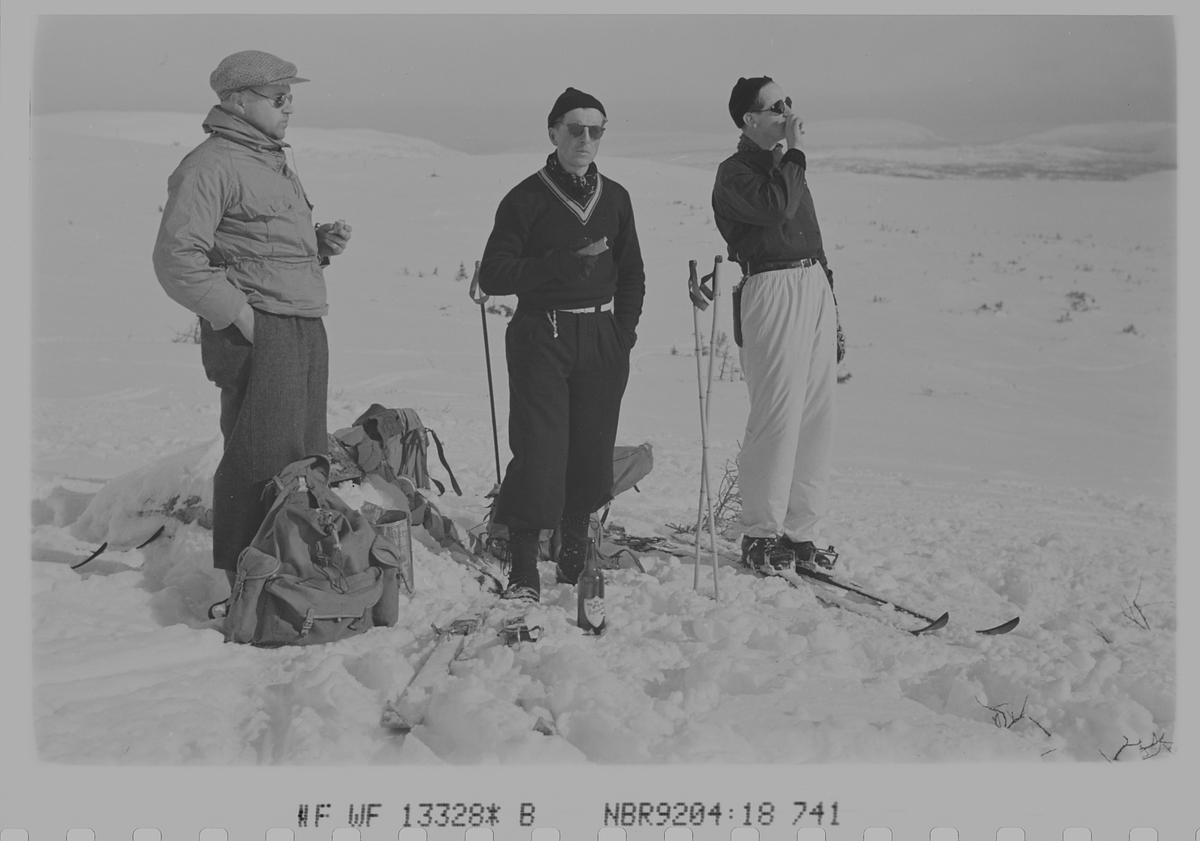 Tre menn på ski tar pust på påsketuren. Fotografert 1940.
