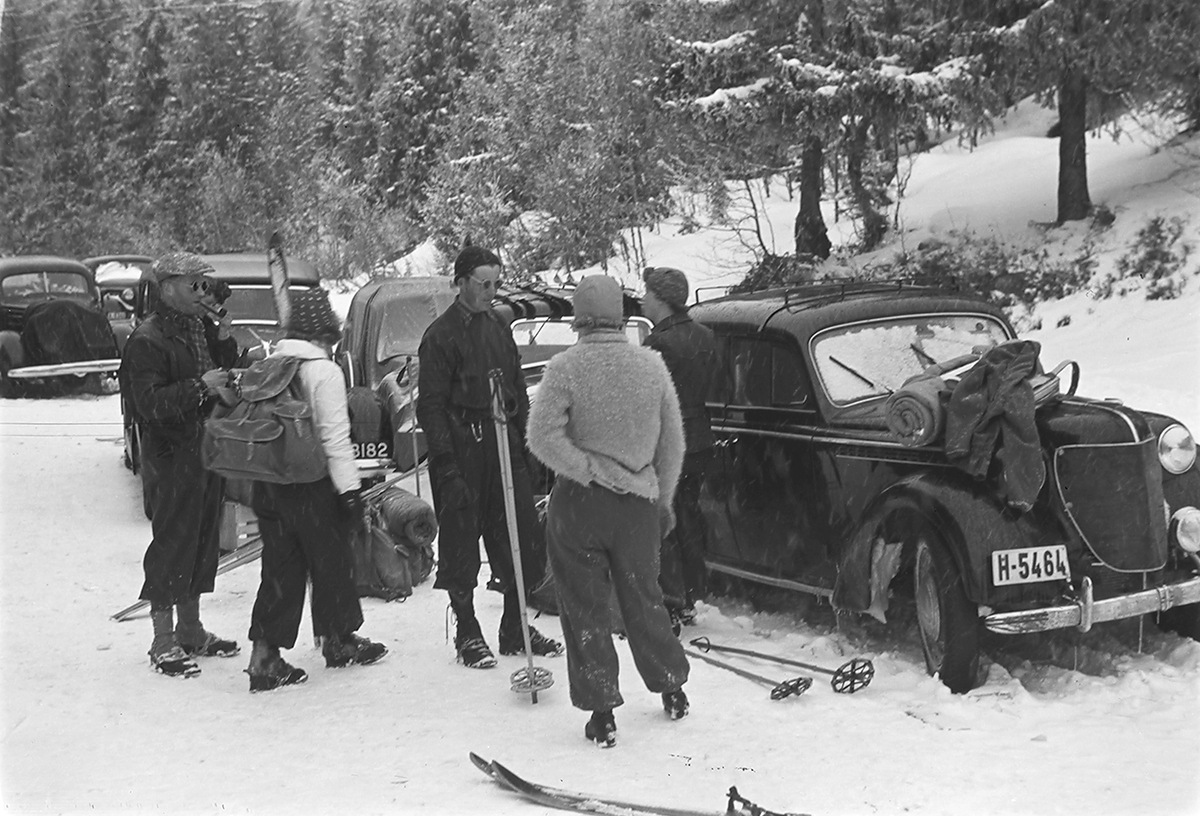 Skigåere utenfor biler (H-5464), klar for hjemtur etter påsken. Fotografert 1940.