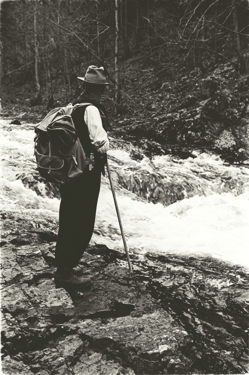 Mann med ryggsekk ved elvebredden, Lysakerelva. Fotografert 1941.