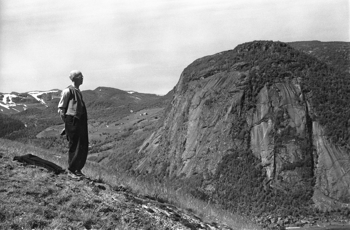Mann tar en hvilepause i fjellheimen.  Solen skinner, jakken ligger på bakken.En flott dag i fjellet med utsikt over de syv blåner.