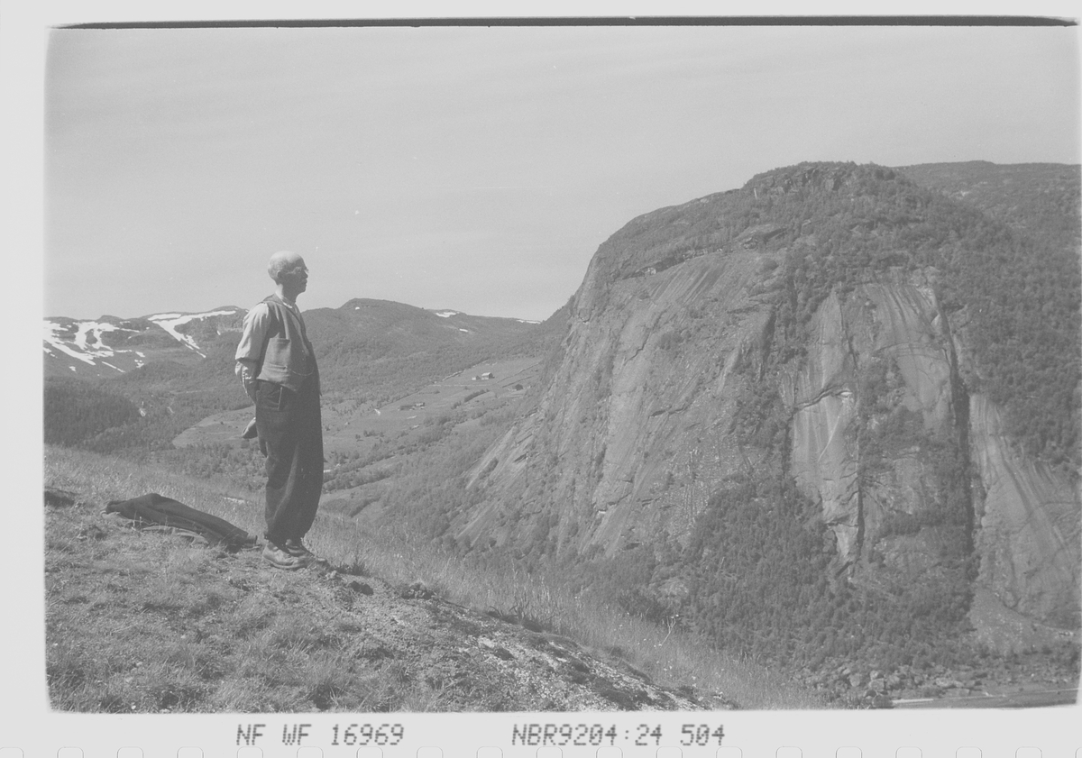 Mann tar en hvilepause i fjellheimen.  Solen skinner, jakken ligger på bakken.En flott dag i fjellet med utsikt over de syv blåner.