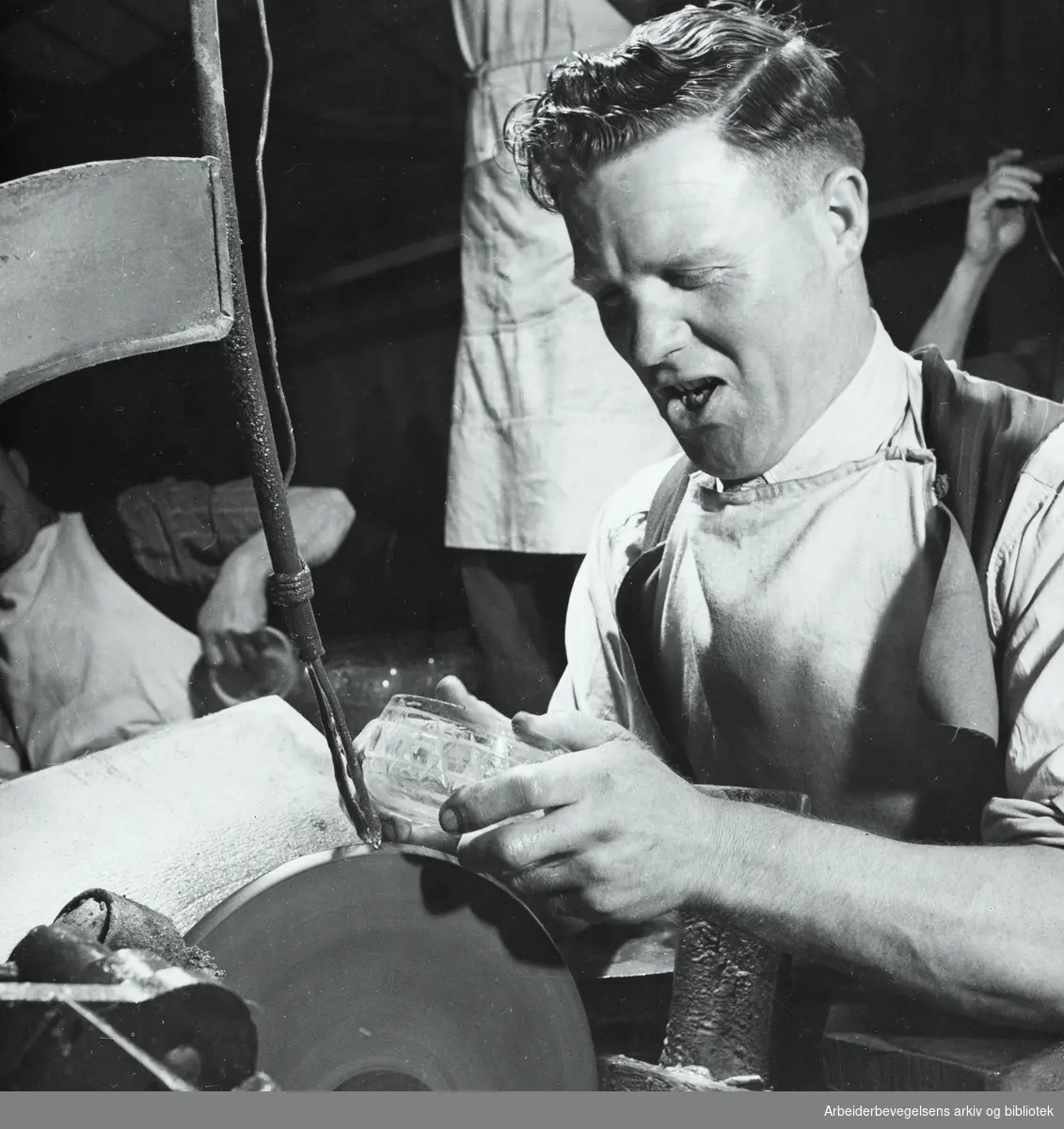 Arbeidslivsreportasje fra glassindustrien i Stourbridge, England. 1949. Høy trivsel blant de ansatte. Ikke uvanlig å synge til arbeidet. Gjennomsnitts levealder for en glassblåser er 73 år (1949).