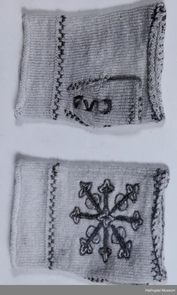 Ull, hvite. Strikket. Håndbaken prydet med broderte 8-bladsroser i 2 nyanser grønt med rød kontur. Røde og grønne border.  
R.B.S.