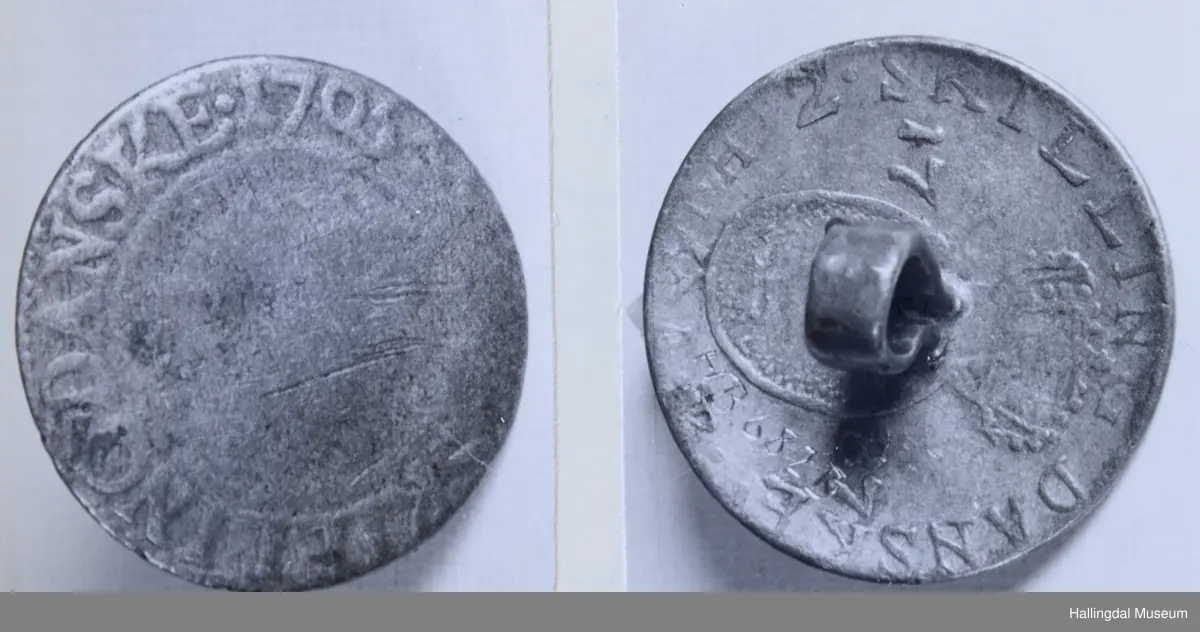 Myntknapp, sølv. Laget av mynt. 
a) Baksiden merket med det kronede dobbeltmonogram F.4. Framsiden med: "..Skilling danske 1705".
b) Baksiden merket: "2 skilling danske 1779" samt våpenmerke. Framsiden sterkt avslitt.
c) Baksiden merke: "2 skilling danske 1786", samt våpenmerke. Framsiden sterkt avslitt.
d) Baksiden merket: "2 skilling danske 1787", samt våpenmerke. På framsiden rester av kronet C7.
e) Baksiden merket med kronet C7 (?), framsiden helt avslitt.
R.B.S.