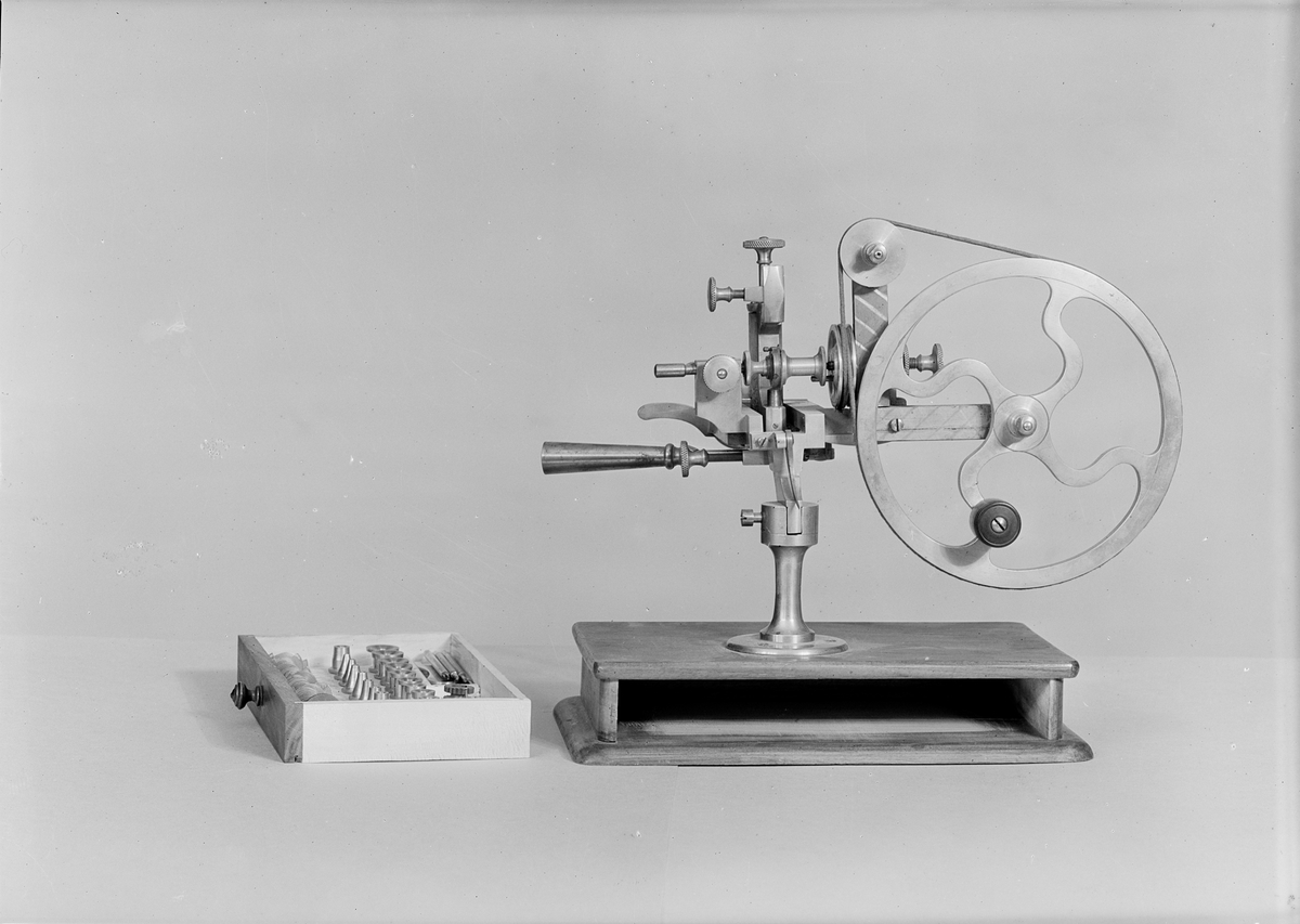 Kuggskärningsmaskin för hjul till klockor. Fotplattans längd: 255 mm, bredd: 160 mm. 47 st. lösa delar, varav 6 st. ursprungligen inte hör till apparaten.