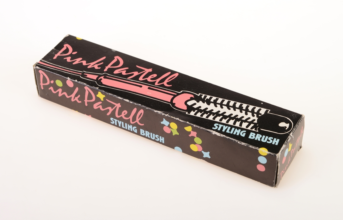 En stylingbørste av typen "Pink Pastell" i originalemballasje. Børsten har smal sylindrisk form av rosa plast. I den ene enden er det festet en svart elektrisk ledning. Børstedelen er sylindrisk med avrundet tupp og med pigger av plast. Det er rader med 15 pigger på hver rad. Esken er av kartong og har svart bunnfarge. Det står "Pink Pastell" på alle sider. på forsiden er det tegning av børsten. På undersiden av esken er det produktinformasjon. Det er spredt "konfetti" jevnt over hele esken i fargene rosa, lys blått, lys grønt og gult. I esken ligger det en bruksanvisning/garantibevis på norsk, finsk, svensk og dansk.
