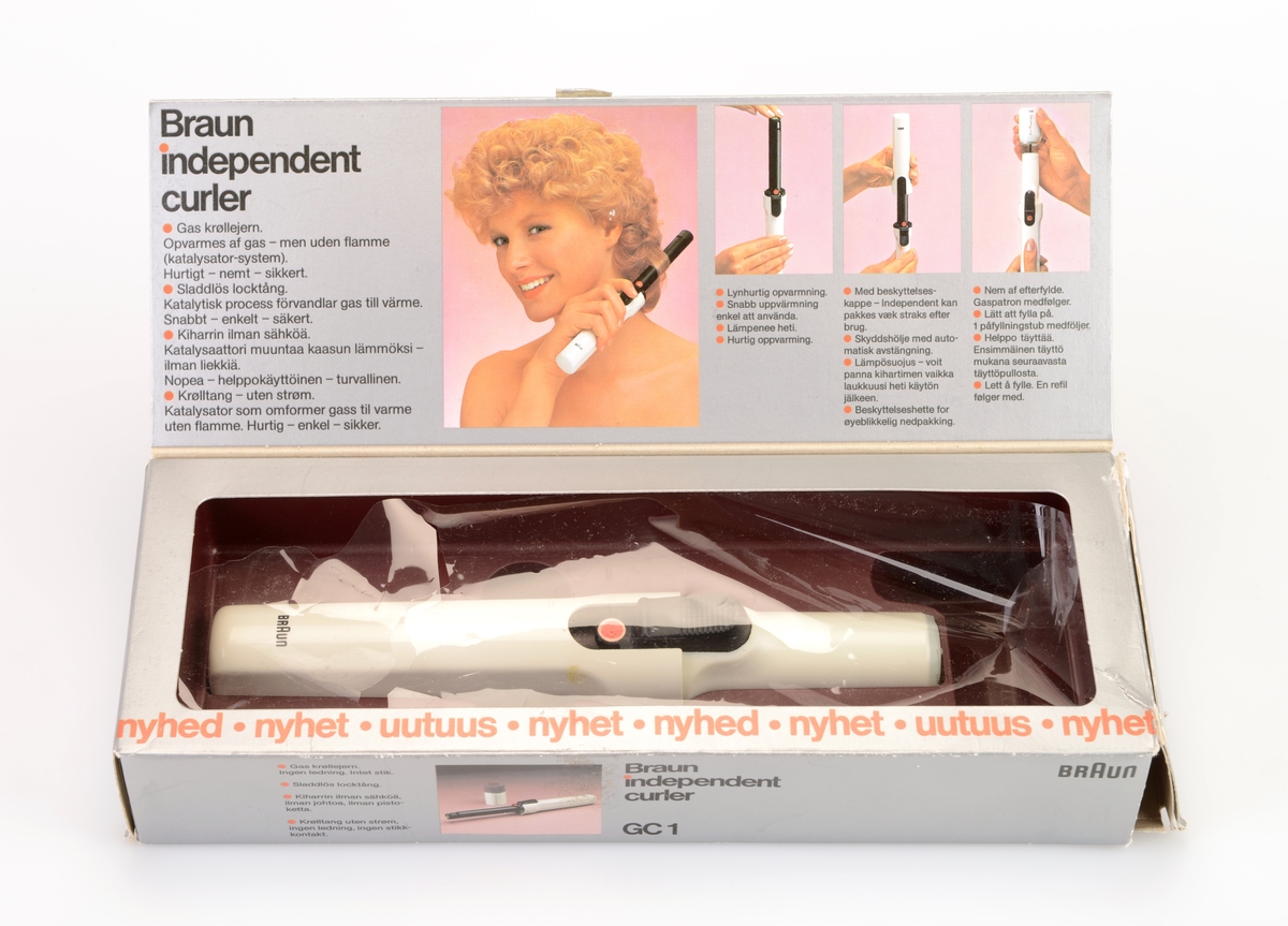 En krølltang av typen "Braun independent curler" i originalemballasje. Esken er av papp og har tekst/illustrasjoner på alle sider. Det er blant annet flere fotografier av krølltangen asmt fotografier som visr at den tar liten plass og at man kan fikse håret når som helst og hvor som helst. Esken åpnes på toppen og henger fast i bakkanten på esken. På undersiden av lokket er det informasjon og illustrasjoner som informerer om bruk av krølltangen. I eskdedelen er det et "utstillingsvindu" delvis dekket med plast. Krølltangen ligger i en burgunderfarget plastinnsats som er formet etter tangens deler. Krølltangen er to deler og laget av hvit plast og svart metall. på tangens håndtak er det en knapp somtrykkes ned og da går en del av tangen opp lsik at man kan rulle håret opp. Til hører det også til en beskyttelseshette av hvit plast. Gassbeholderen mangler.