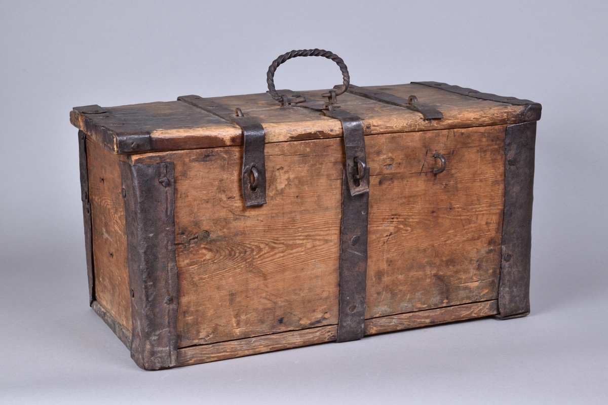 Skrin av trä tillverkat i trä, med lock. Rektangulär och djup, med utanpåliggande järnbeslag. På ovansidan handtag av spiralvridet järnband. Lockets insida med stämpel.


Funktion: Förvaring av föremål