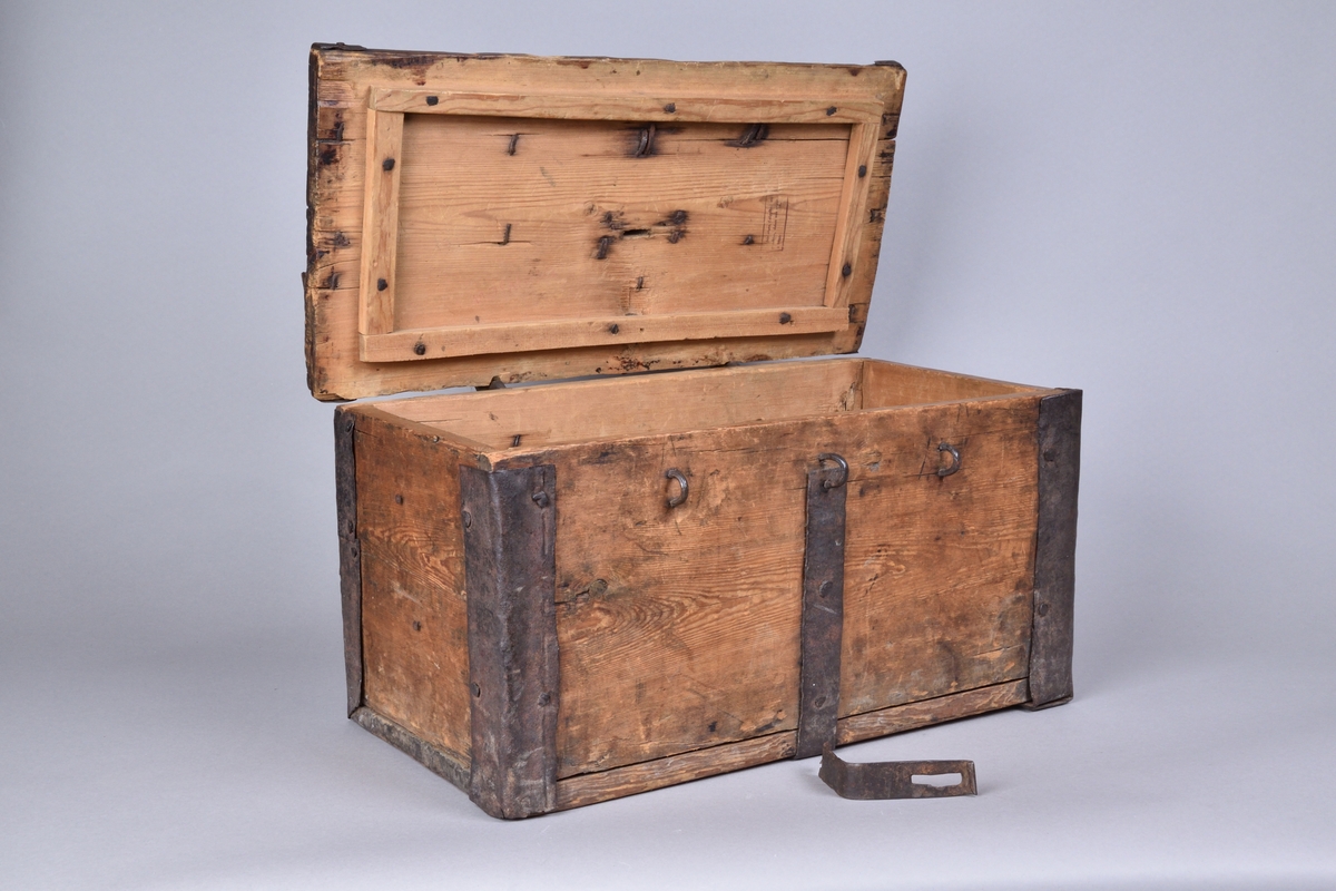 Skrin av trä tillverkat i trä, med lock. Rektangulär och djup, med utanpåliggande järnbeslag. På ovansidan handtag av spiralvridet järnband. Lockets insida med stämpel.


Funktion: Förvaring av föremål