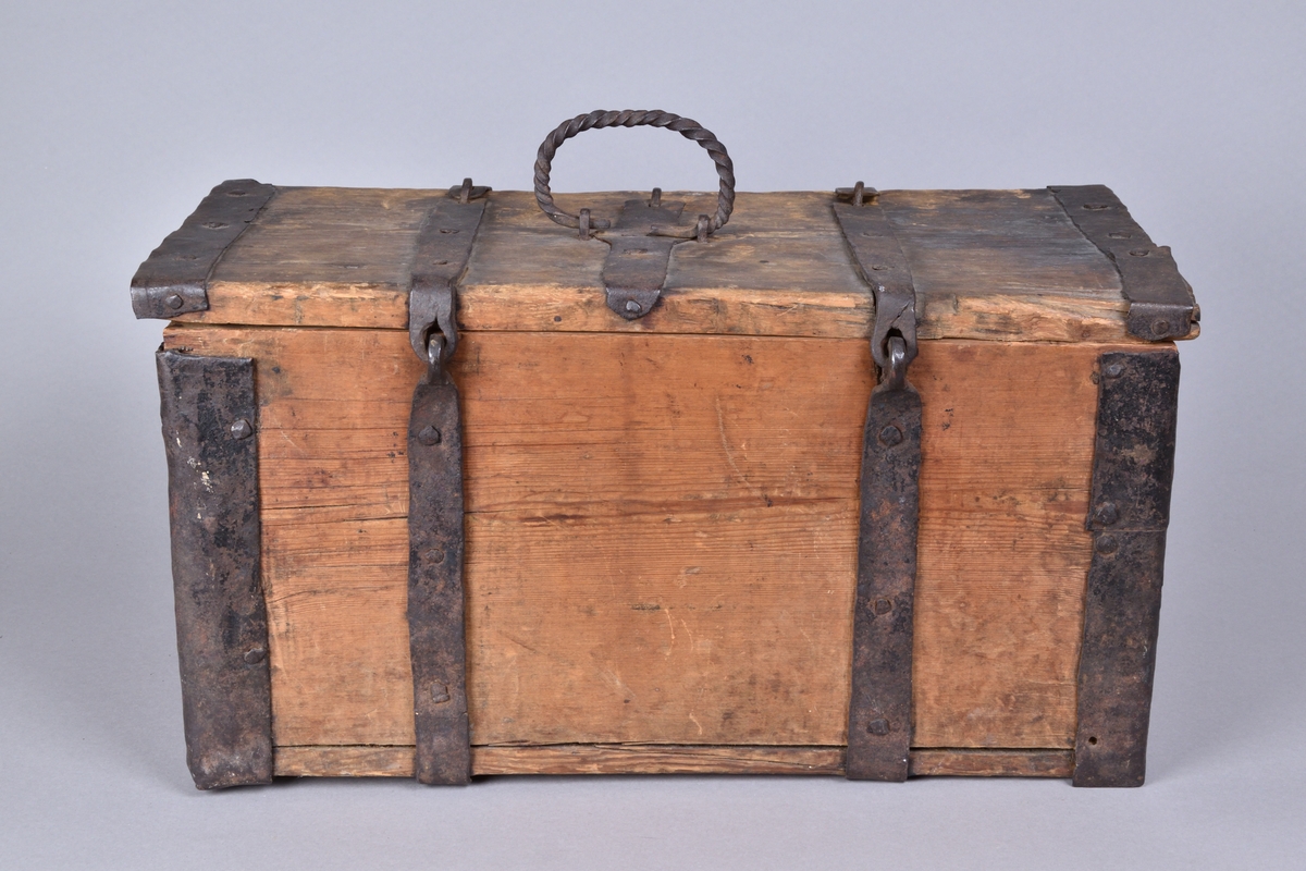 Skrin av trä tillverkat i trä, med lock. Rektangulär och djup, med utanpåliggande järnbeslag. På ovansidan handtag av spiralvridet järnband. Lockets insida med stämpel.


Funktion: Förvaring av föremål