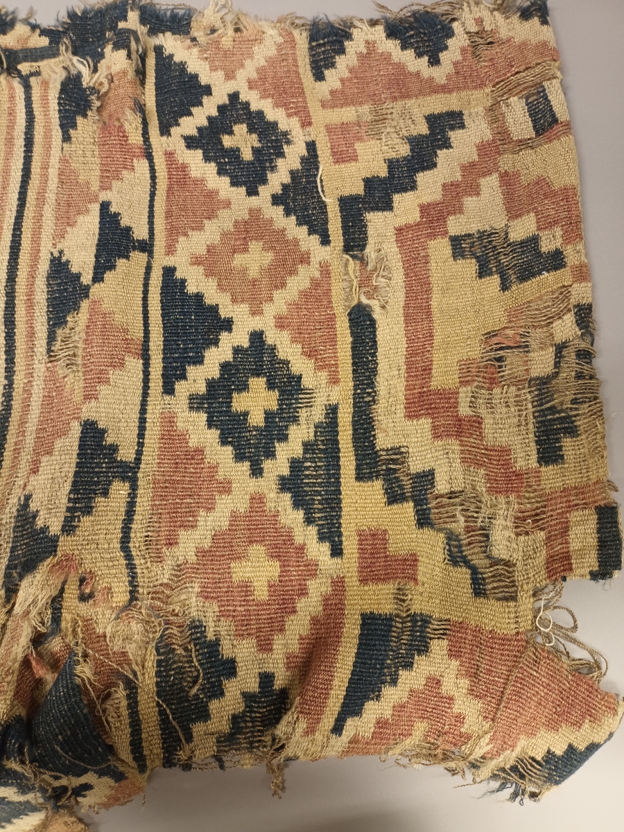 Ruteåkle i smett med enkle slyng over fire tråder.Truleg heimspunne og heimefarga garn både i renning og innslag. To tråds ullgarn, relativt hardt spunne. Fire åttebladsroser, ruteborder og striper nederst. Smal fald i begge korsidene. Teppet er særs slitt og falma.