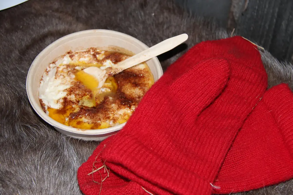 Foto av en tallerken med julegrøt og et par røde votter