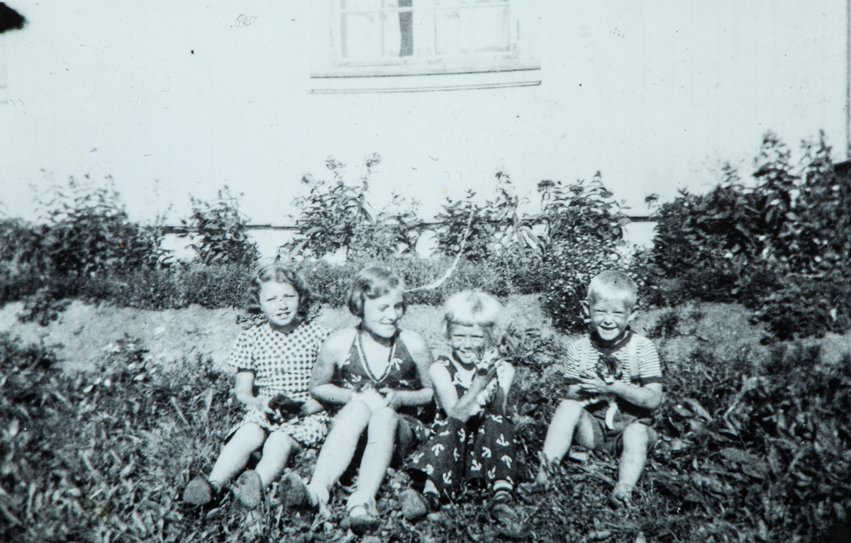 Øvre Tomter (60/1). Fire barn i husveggen på Øvre Tomter. Helga Prestrud nr. 3 fra venstre, Helge Andreas Prestrud til høyre.