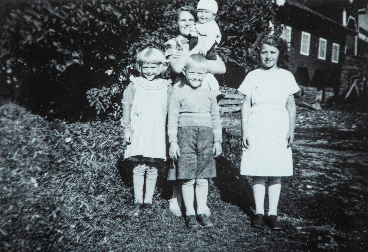 Øvre Tomter (60/1). Barnepike på Øvre Tomter med barna på garden. Helga, Helge Andreas, på armen Kristen Prestrud. Nabojenta Pauline Husom.