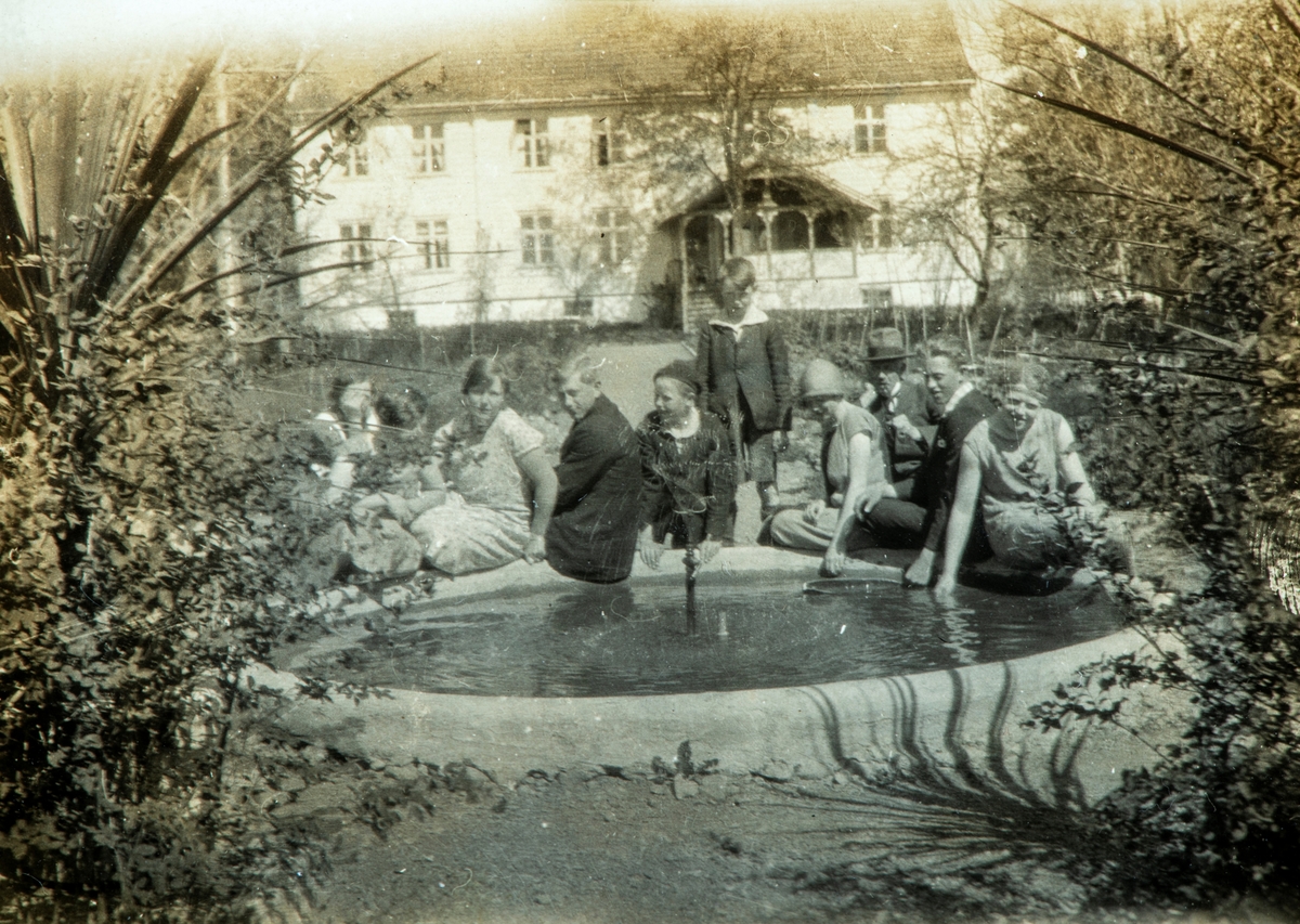 Familie fra Karset samlet rundt basseng i hagen på Hafsal (77/1)? Ingeborg Karset nr. to fra venstre, Pauline Karset nr. tre, Helge Prestrud nr fire (senere gift med Pauline). Helge Karset (med hatt). 1920-åra.