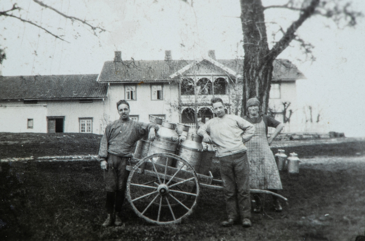 Bilde fra Sømådalen.  Arbeidsfolk med håndkjerre med melkekjeler.