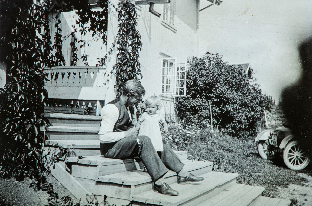 Øvre Tomter (60/1).  Mann og pike sittende på trappa på Øvre Tomter, Helga Prestrud (t.h.).