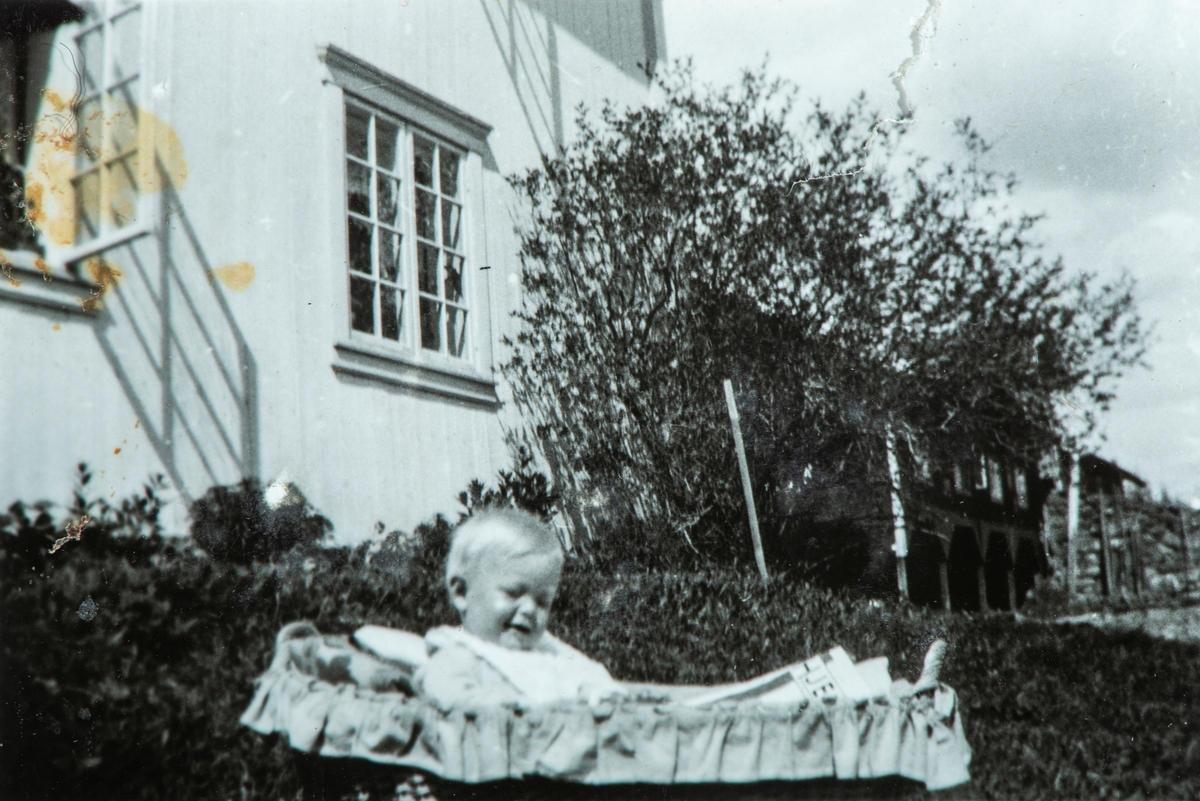 Øvre Tomter (60/1). Helge Andreas Prestrud sittende ute ved husveggen på Øvre Tomter.