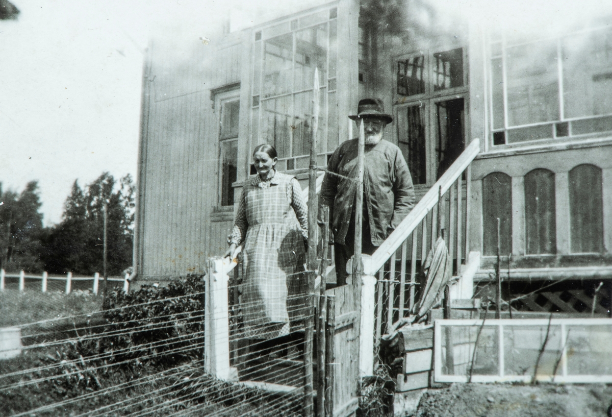 Øvre Tomter (60/1). Kristoffer Tomter og husholderska Gønner Toresen på trappa på Lille-Tomter ca. 1930. Kristoffer Tomter var gift med Anne f. Dystvold. De brukte Øvre Tomter fra 1882 til 1920. De var barnløse. Han solgte garden til fetteren Andreas Prestrud på Hanums sønn Helge Prestrud i 1920 og bygde villaen Lille-Tomter til seg selv og kona Anne.